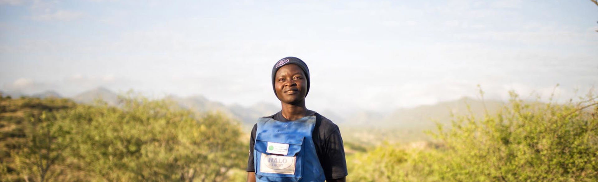 Woman wearing PPE poses in the middle of a field