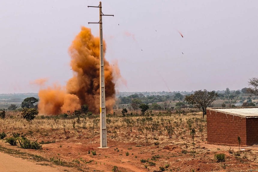 A controlled explosion destroying weapons and ammunition in rural Angola