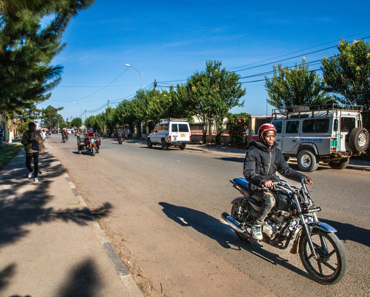 The same area today, now a bustling street known as Avenida 28 de Maio, where children safely attend school and the community thrives.
