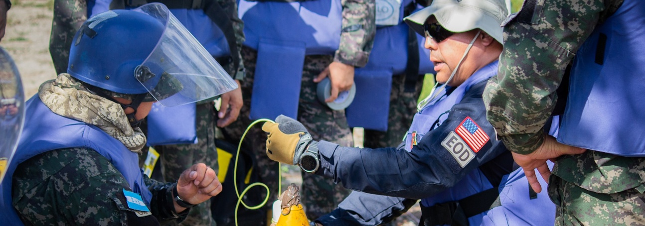 Deminers wearing PPE take on a practical explosive ordnance disposal course