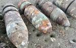 A collection of rusted US six-inch practice projectiles