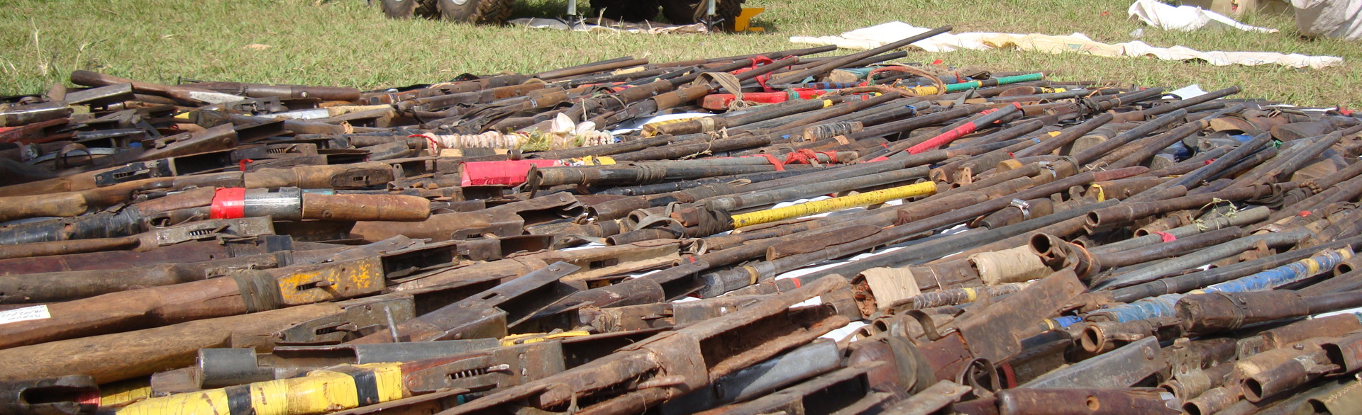 Old rusty weapons lay on grassy ground
