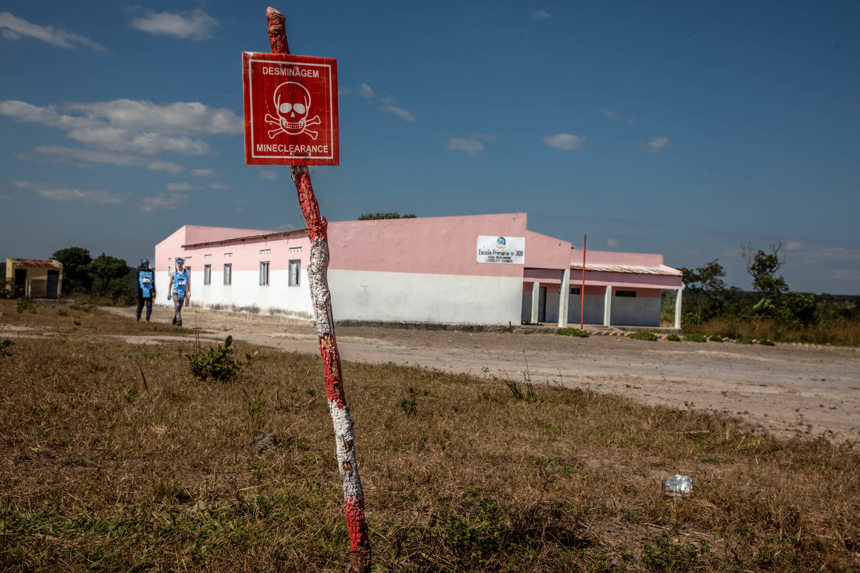 A danger mines sign outside of a primary school located on the edge of a minefield