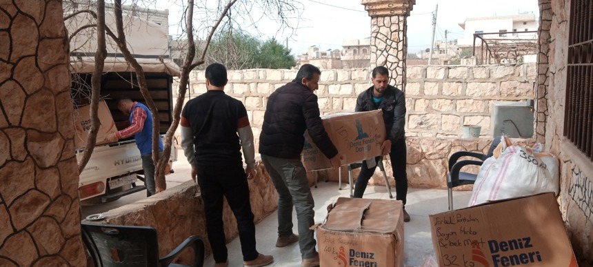 Men unload a van full of boxes and goods