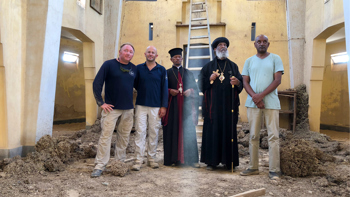 HALO staff stand with religious leaders inside the cleared church