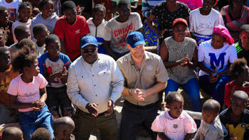 Duke of Sussex with HALO team and local community children.