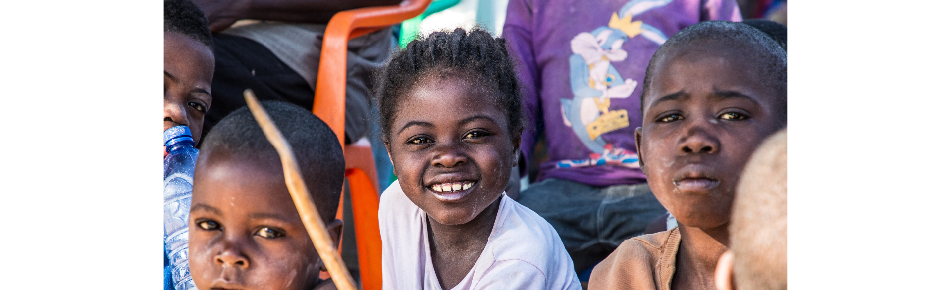 A group of children sit outside