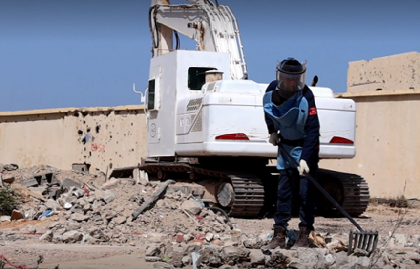 A HALO deminer rakes the ground in front of a mechanical asset in Sirte, Libya