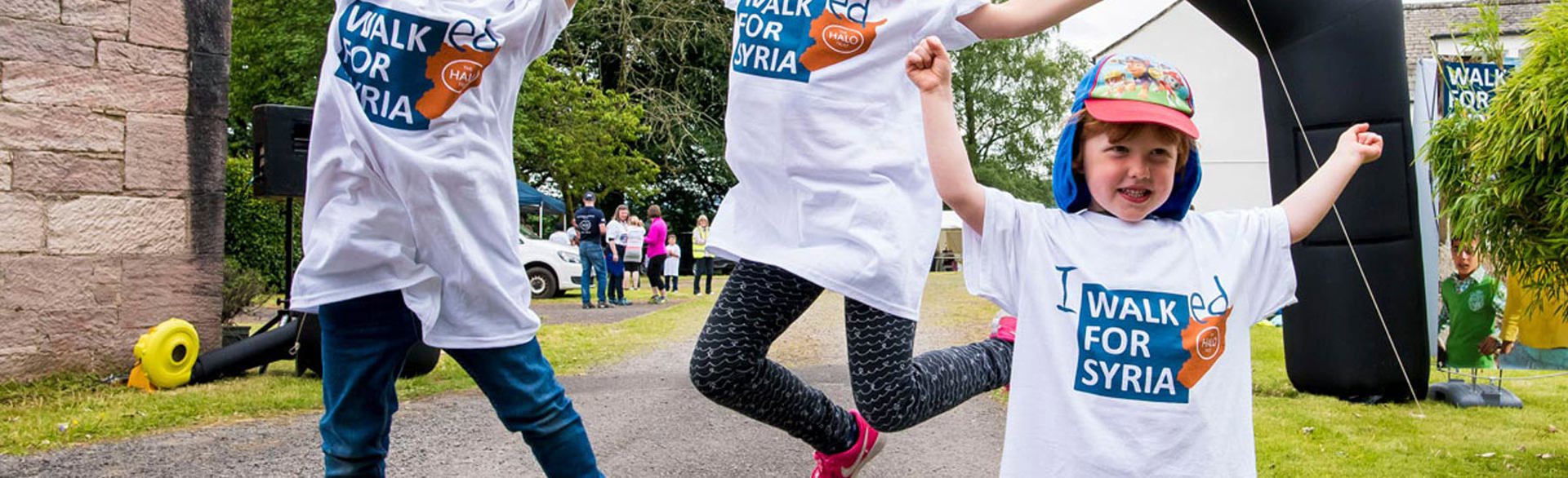 Children jumping at the finish line of a fundraising event for Syria