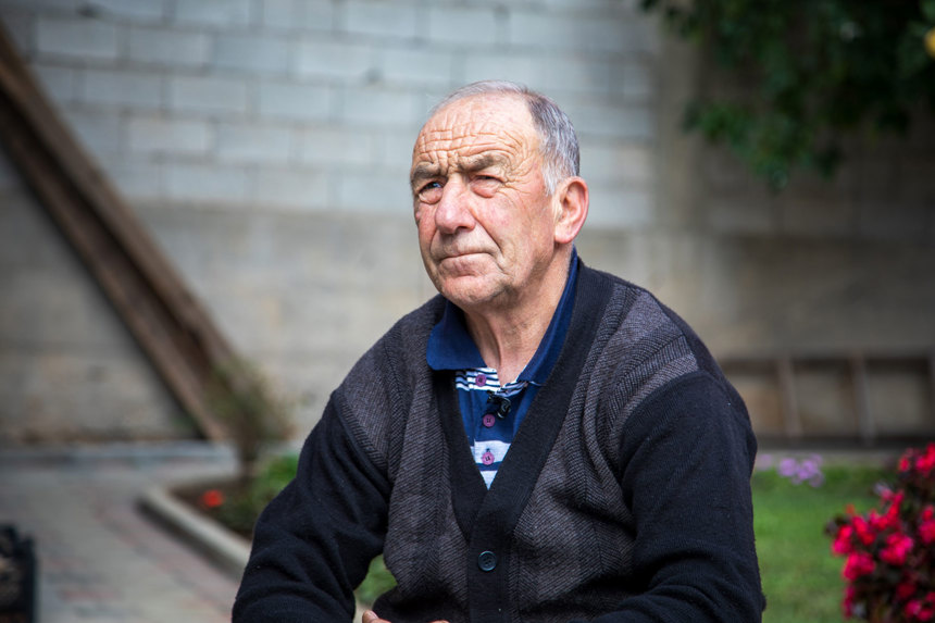 A man sits outside of a building in Kosovo