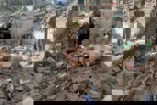 Two locals look through the rubble left after the earthquake in Khost