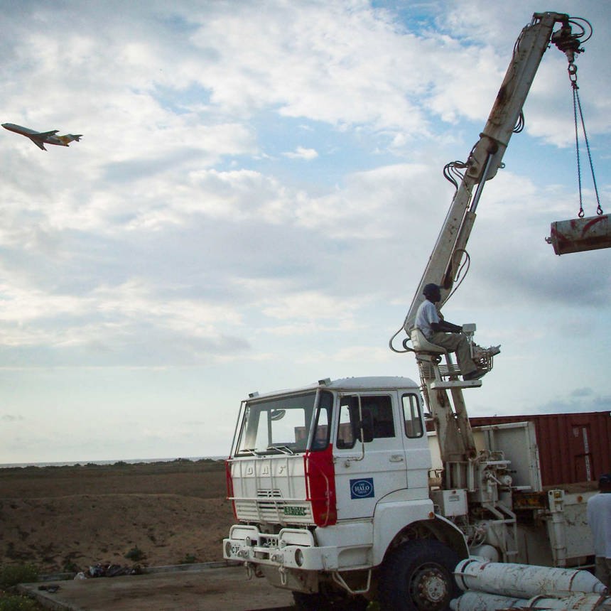 A plane takes off as HALO loads bombs and missiles at Catumbela Airport