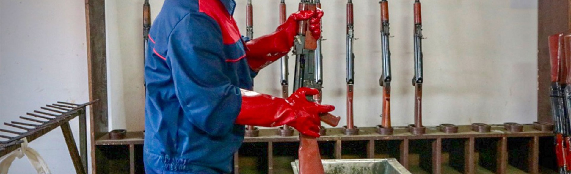 A man holds a gun over a tray of liquid