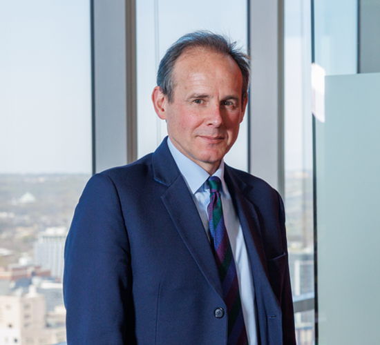 HALO CEO James Cowan stands in front of an urban tower's window