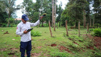 A field data collector in Laos uses a Trimble DA2 GNSS receiver to map survey areas for explosive contamination