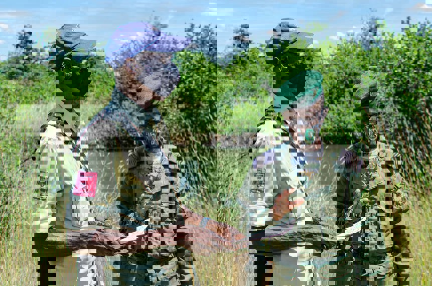 HALO employee holds papers whilst standing next to a soldier outside