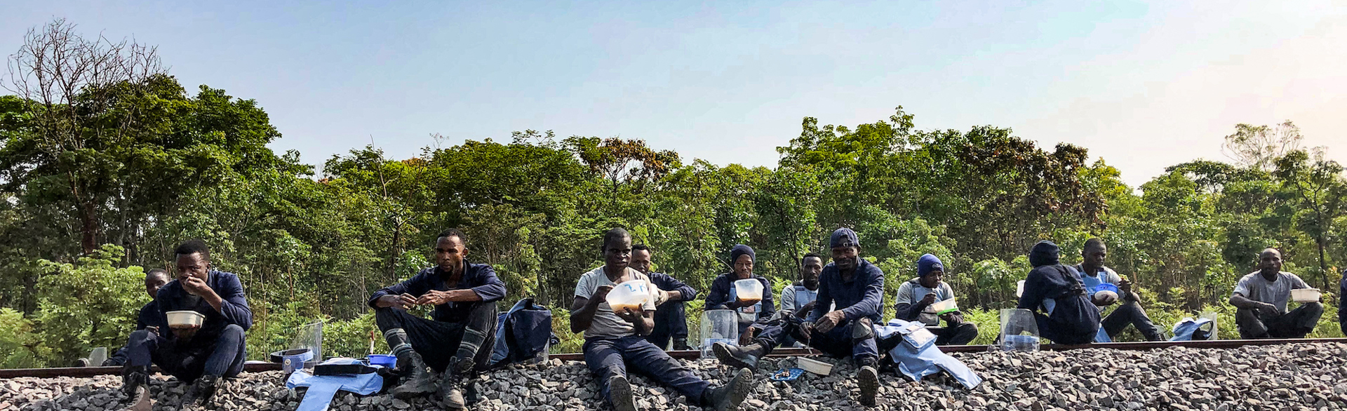 HALO deminers break for lunch and sit on the railway in Angola