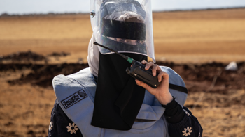 HALO woman deminer wearing PPE on a minefield in Syria