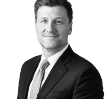 Black and white rendering of Adam Yezerki, posing in a suit before a white background