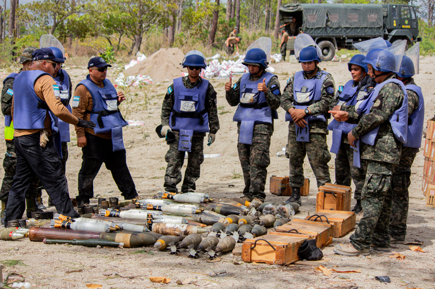 Group of HALO staff inspect a collection of explosives in Honduras