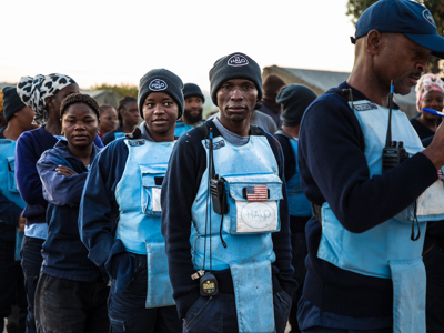 HALO deminers stand in line wearing PPE