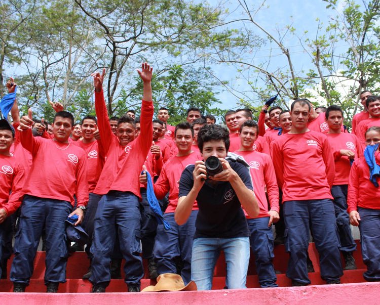 A demining team in Colombia stand behind a photographer holding a camera