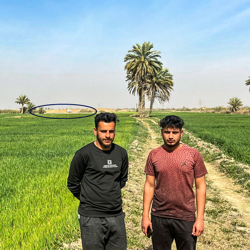 Mohammed Wayed and Ahmed stand on their farm in front of HALO's mechanical clearance operations