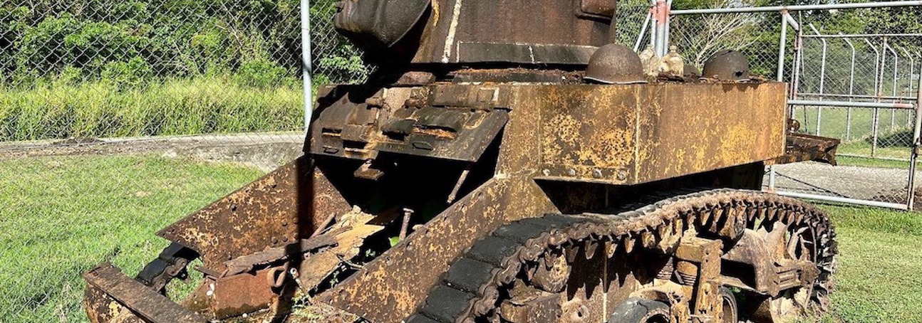 A rusted WW2 tank in a fenced off area in the Solomon Islands