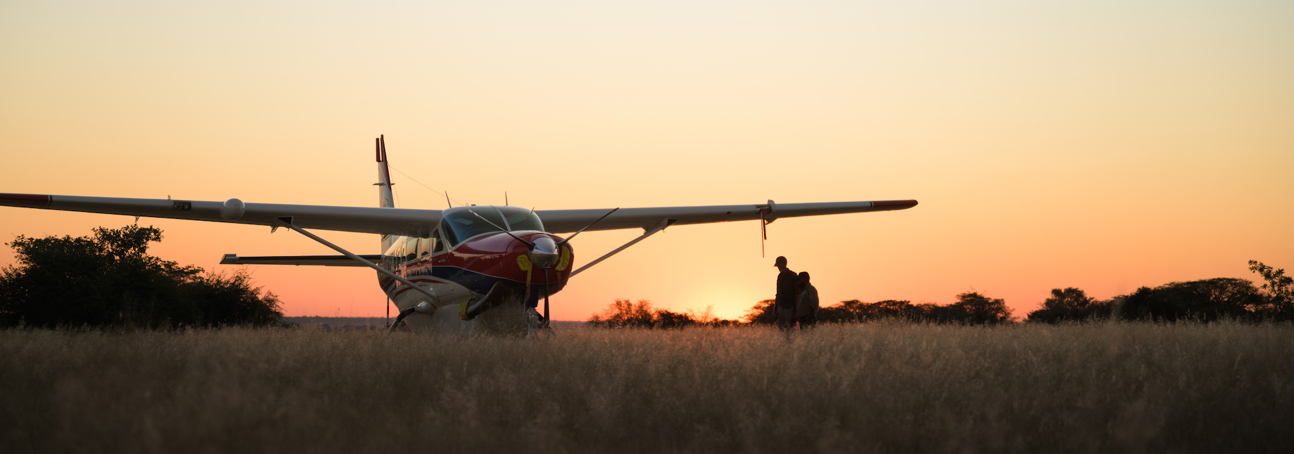 A plane in a grassy field during the sunset in Angola