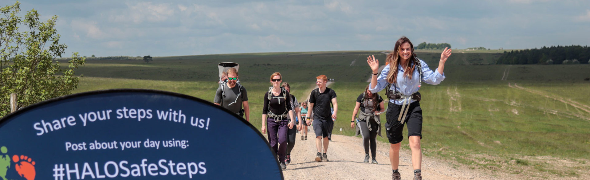 Camilla Thurlow waves whilst walking through a field as part of the Safe Steps fundraising event