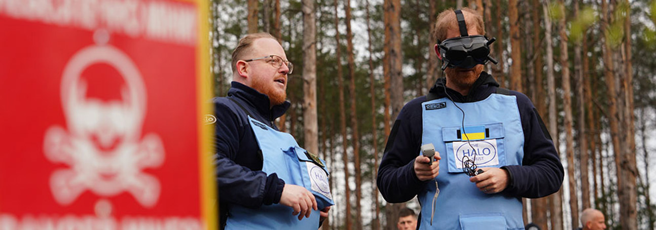 Prince Harry (right) wears a headset and pilots a drone with a HALO team member (left).