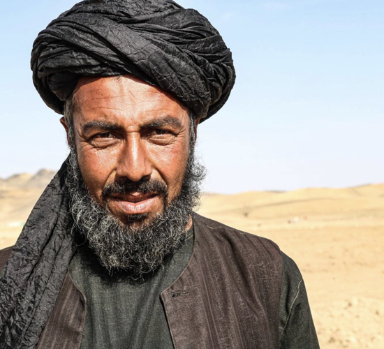 Agha Hamdullah, head of the Petwayi Shura, Kandahar standing in a desert