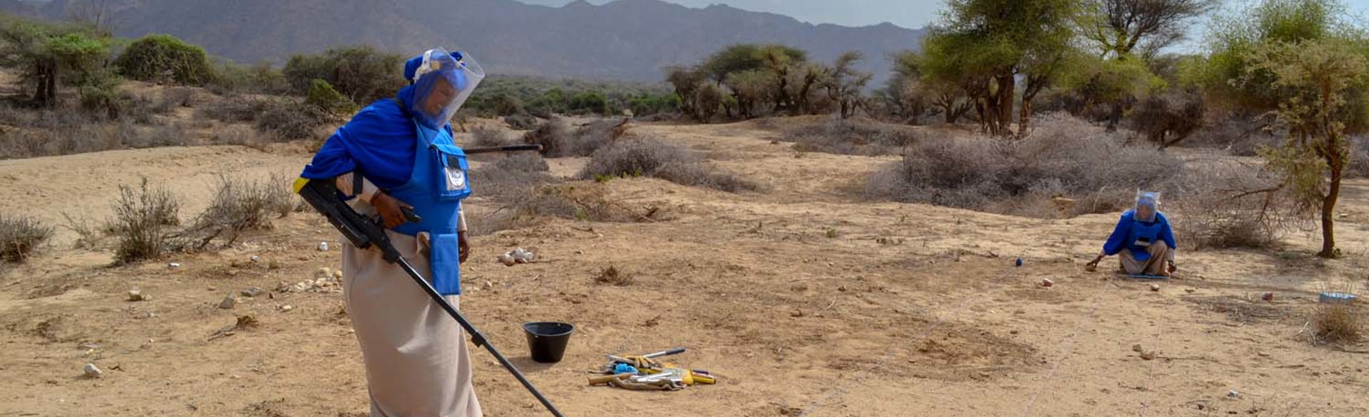 A female HALO deminer uses a metal detector on a minefield in Somalia