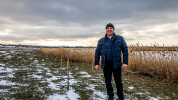 Head of Vasylivka village, Ivan Gentosh, stands next to the Inhulets river where hundreds of explosives were cleared.