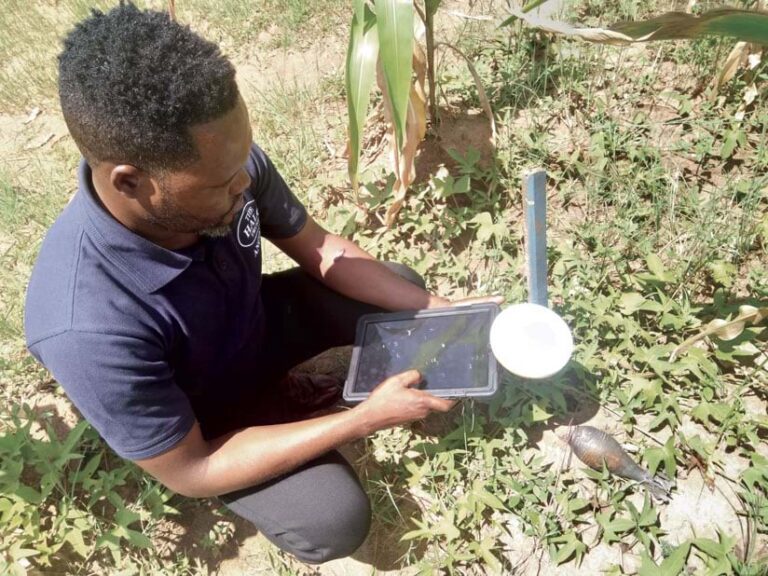 HALO Trust deminer using a Trimble DA2 GNSS receiver to record the coordinates of unexploded ordnance in a rural minefield, showcasing the integration of advanced technology in landmine clearance operations
